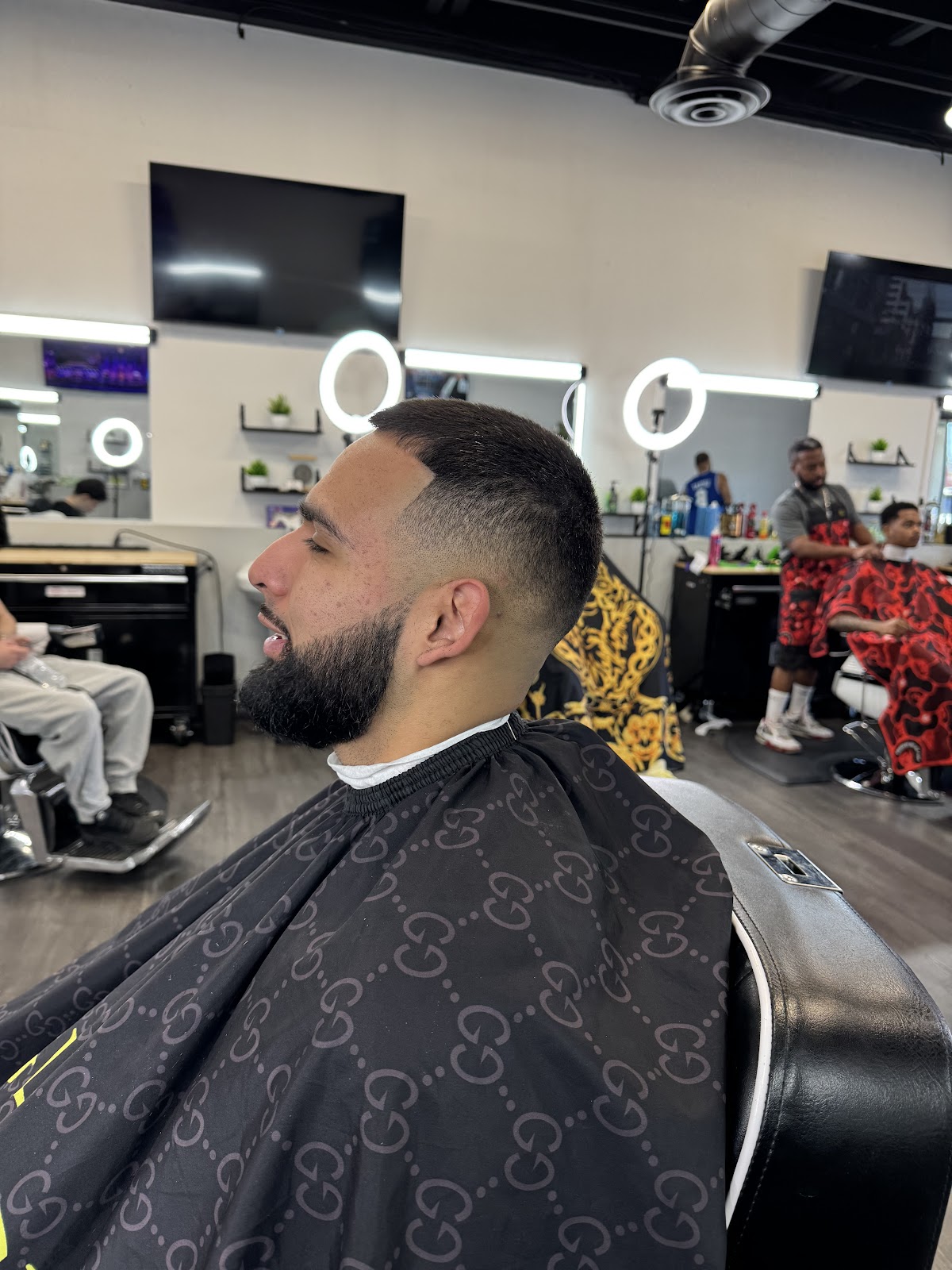 Client with clean low fade and full beard in shop