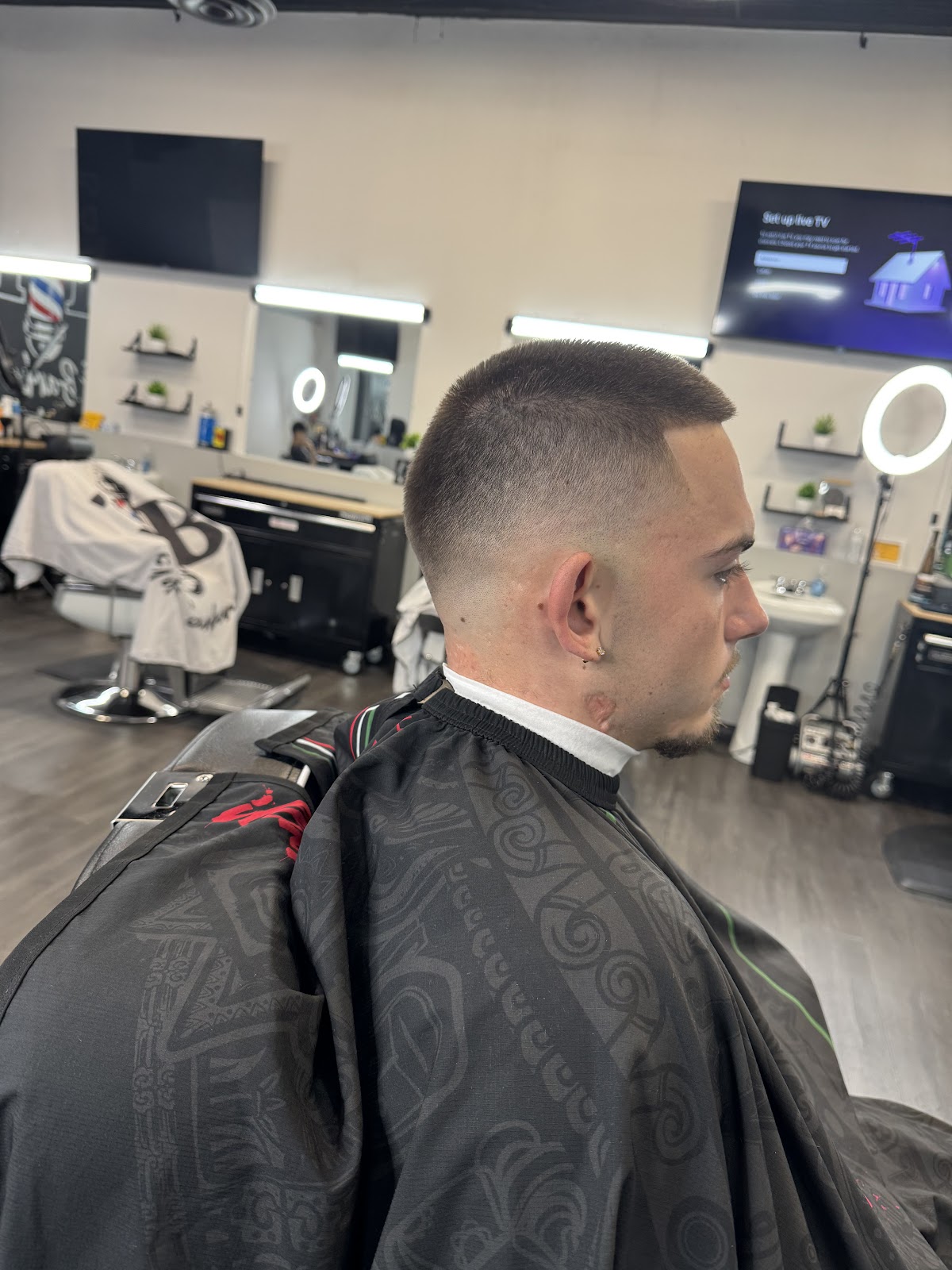 Tight buzz fade side profile inside Elite Barbershop